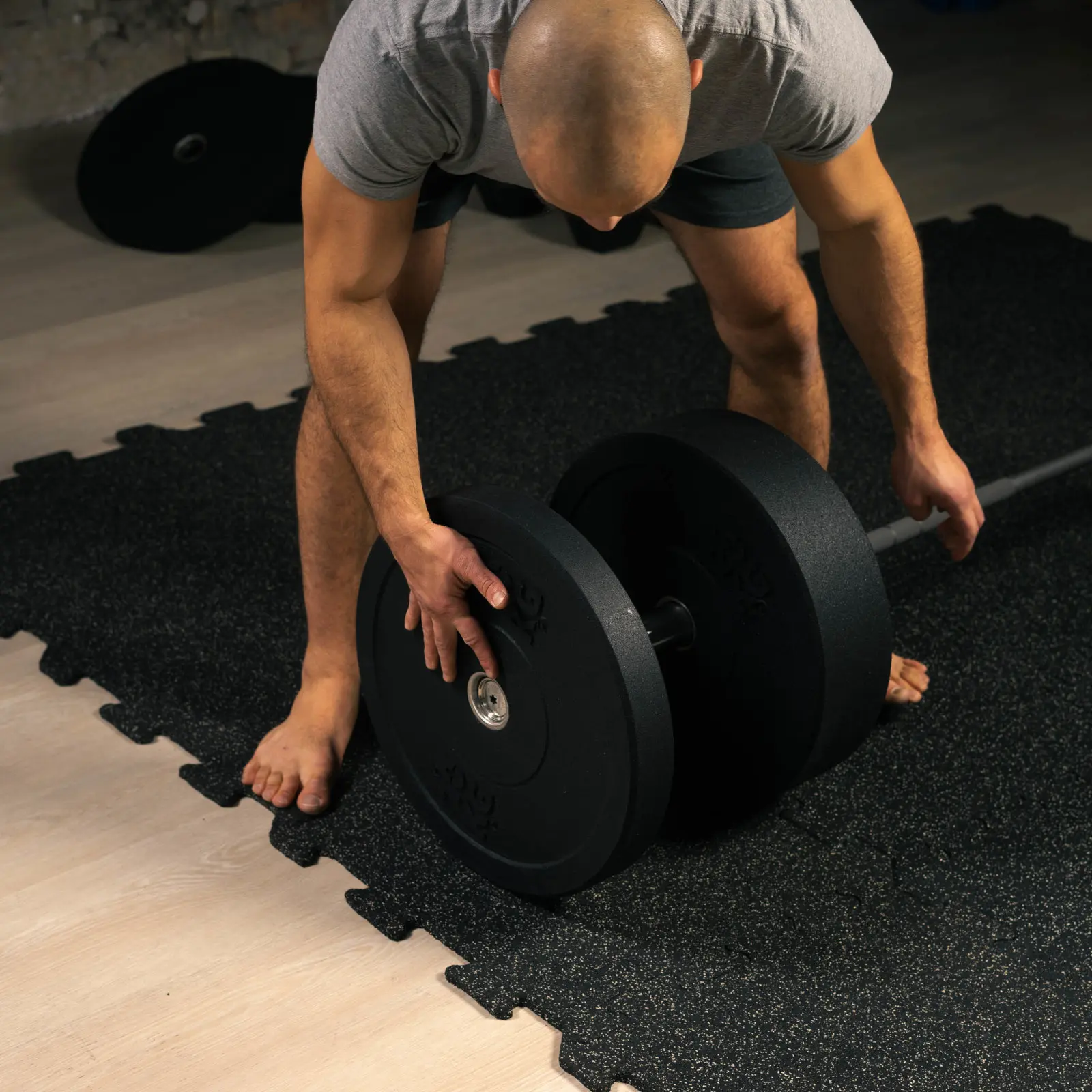Zakładanie talerza Bumper Essential na sztangę olimpijską dzięki tulei 51 mm